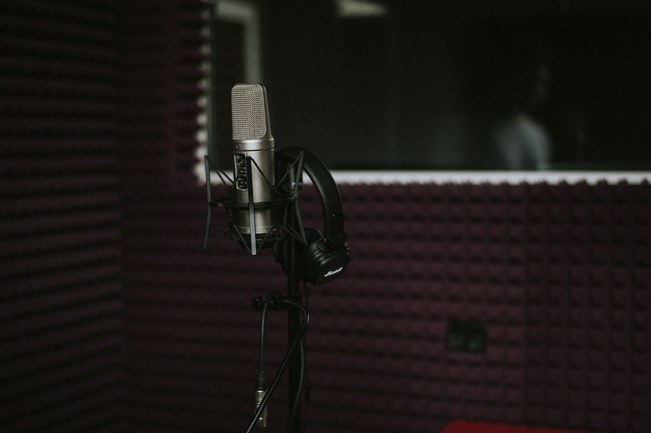 Close-up of a microphone with headphones in a soundproof recording studio.