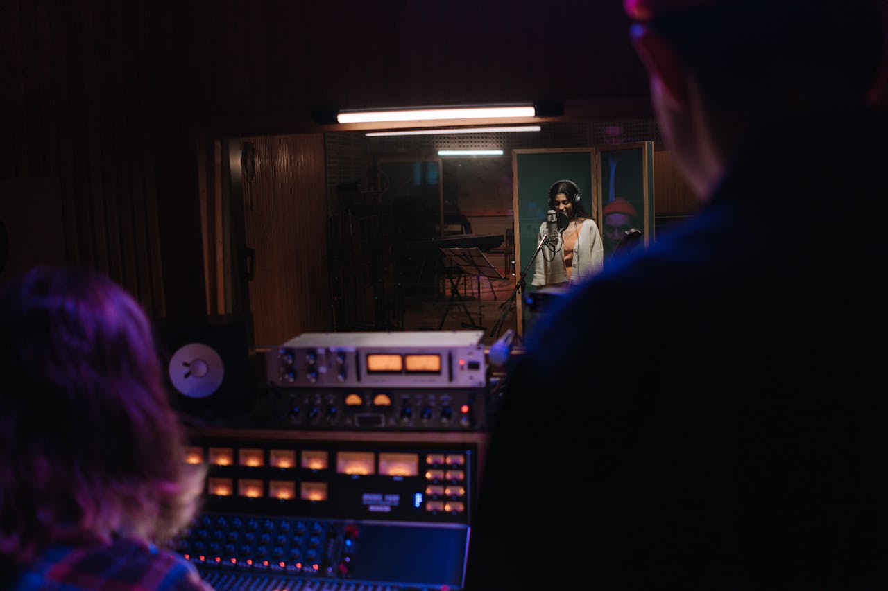 Recording session in a modern music studio with a singer and audio engineers.